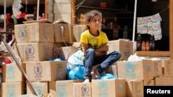 Một bé gái tị nạn người Syria ngồi trên các thùng hàng cứu trợ nhân đạo, tại trại tị nạn Al Zaatri ở Jordan, 8/9/13