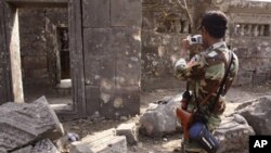 A Cambodian army soldier takes photographs of the damaged section of Cambodia's famed Preah Vihear temple, a UNESCO World Heritage site. Cambodia angrily rejected Thailand's accusation that Cambodian troops used a centuries-old Hindu temple along their di