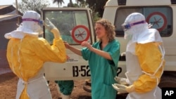In this photo provide by MSF, healthcare workers prepare isolation and treatment areas for Ebola in Gueckedou, Guinea, Mar. 28, 2014.