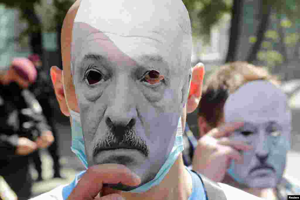 Participants hold paper masks depicting Belarusian President Alexander Lukashenko during a rally to support the opposition of Belarus in front of the Belarusian embassy in Kyiv, Ukraine.