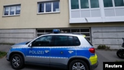 FILE - A police car standing in front of a building where a suspected Salafist Islamist extremists was believed to live, in Oberursel near Frankfurt, Germany, April 30, 2015. 