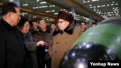 김정은 북한 국방위원회 제1위원장이 핵무기 연구 부문 과학자, 기술자들을 만나 핵무기 병기화 사업을 지도하는 모습을 지난 3월 조선중앙통신이 보도했다. (자료사진)