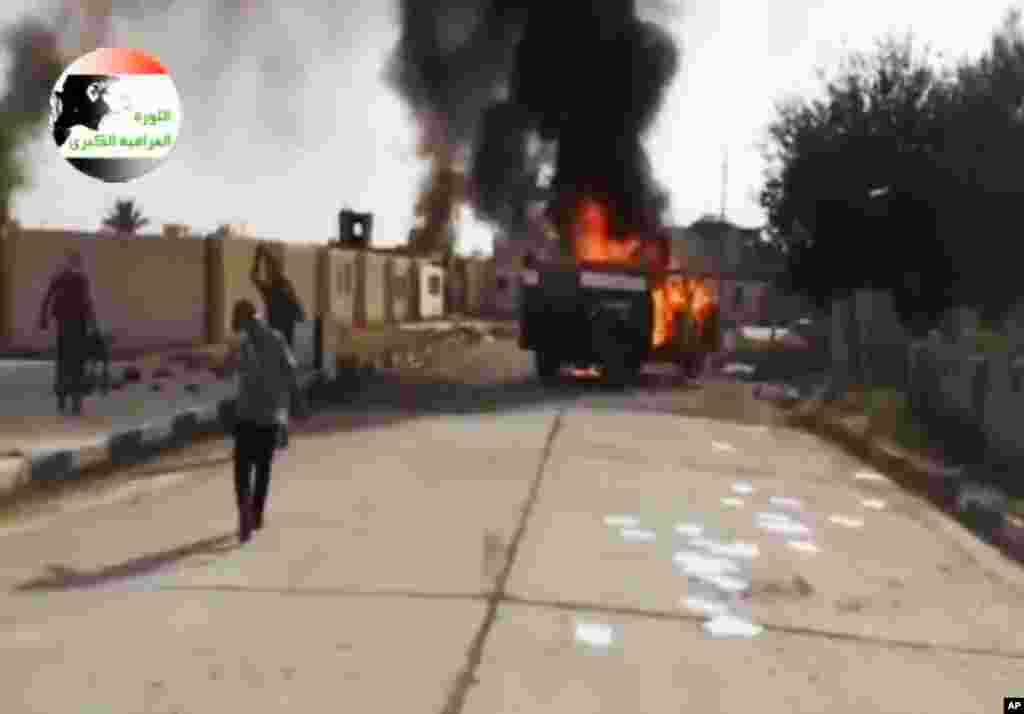 This image made from video posted by Iraqi0Revolution, a group supporting ISIL, shows militants at the Al-Sharqat base north of Tikrit, Iraq, June 11, 2014.
