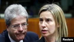 European Union foreign policy chief Federica Mogherini and Italian Foreign Minister Paolo Gentiloni (L) attend a meeting of European Union foreign and defence ministers at the EU Council in Brussels, Belgium, May 18, 2015. 
