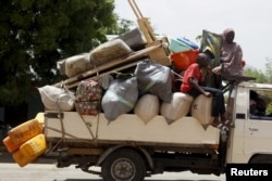 FILE - People travel in a truck with their belongings as they return after the Nigerian military recaptures the town of Michika from Boko Haram, Adamawa state, May 10, 2015.