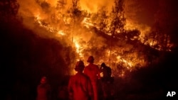 Firefighters monitor a backfire while battling the Ranch Fire, part of the Mendocino Complex Fire, on Aug. 7, 2018, near Ladoga, Calif. (AP Photo/Noah Berger)