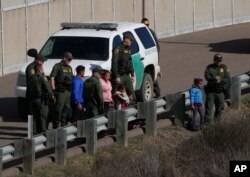 FIEL - A woman and children stand amidst U.S. Border Patrol agents after crossing illegally over the border into San Diego, California, as seen from Tijuana, Mexico, Dec. 9, 2018.