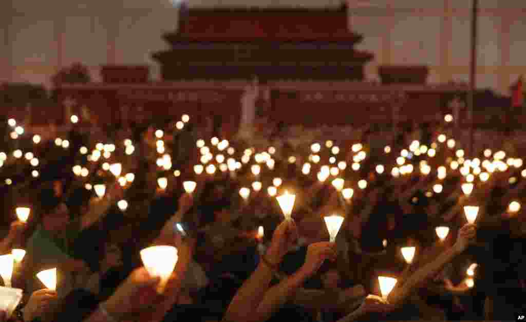 Tens of thousands of people attend a candlelight vigil at Hong Kong's Victoria Park in Hong Kong Monday, June 4, 2012 to mark the 23rd anniversary of the Chinese military crackdown on the pro-democracy movement in Beijing. The background shows a picture t