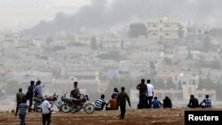 Turkish Kurds watch over Syrian town of Kobani from hill near Mursitpinar border crossing, southeastern Turkey, Oct. 11, 2014.