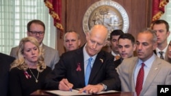 En la foto el gobernador Rick Scott firma la Ley de Seguridad Pública "Marjory Stoneman Douglas" el viernes 9 de marzo de 2018. 