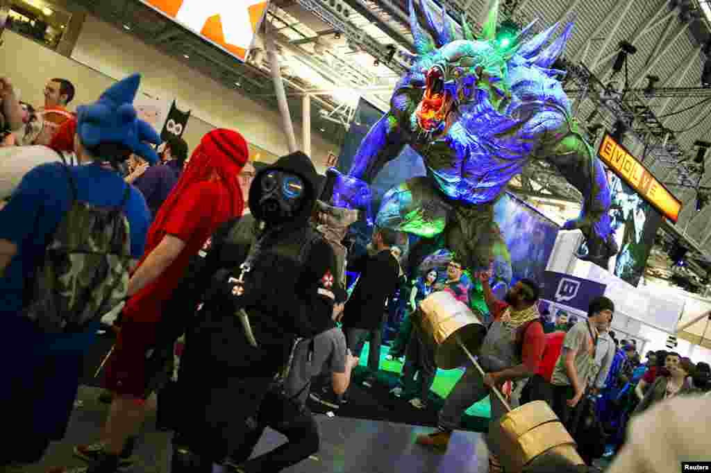 A monster character from the game Evolve looms over gaming enthusiasts at the PAX East convention in Boston, Massachusetts, April 12, 2014.