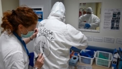 A nurse writes the name of Italian anaesthesiologist Doctor Marino De Rosa on the back of his Personal Protective Equipment (PPE) at the ICU division of the Covid unit where he works at the San Filippo Neri hospital, in Rome, on April 29, 2020 as the coun