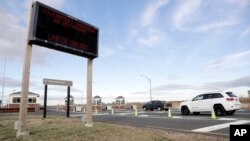 FILE - Vehicles roll into the Gateway National Recreation Area-Sandy Hook near a sign at the entrance warning visitors of limited services such as closed restrooms during the partial government shutdown in Highlands, N.J., Jan. 3, 2019.