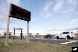 FILE - Vehicles roll into the Gateway National Recreation Area-Sandy Hook near a sign at the entrance warning visitors of limited services such as closed restrooms during the partial government shutdown in Highlands, N.J., Jan. 3, 2019.
