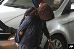 Vietnamese Doan Thi Huong is escorted by police as she arrives at Shah Alam High Court in Shah Alam, Malaysia, Monday, March 11, 2019. (AP Photo/Yam G-Jun)