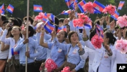 Cambodian students wave their national flags during a ceremony to celebrate the country's 59th Independence Day from France, at the Independence Monument in Phnom Penh, Cambodia, Friday, Nov. 9, 2012. (AP Photo/Heng Sinith