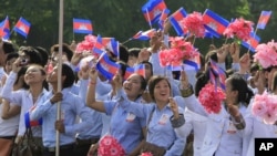 Cambodian students wave their national flags during a ceremony to celebrate the country's Independence Day from France.