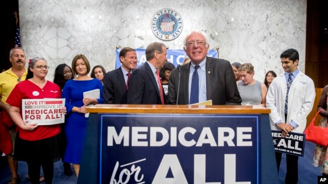 FILE - Sen. Bernie Sanders, I-Vt., is joined by Democratic Senators and supporters as he arrives for a news conference on Capitol Hill in Washington, Sept. 13, 2017.