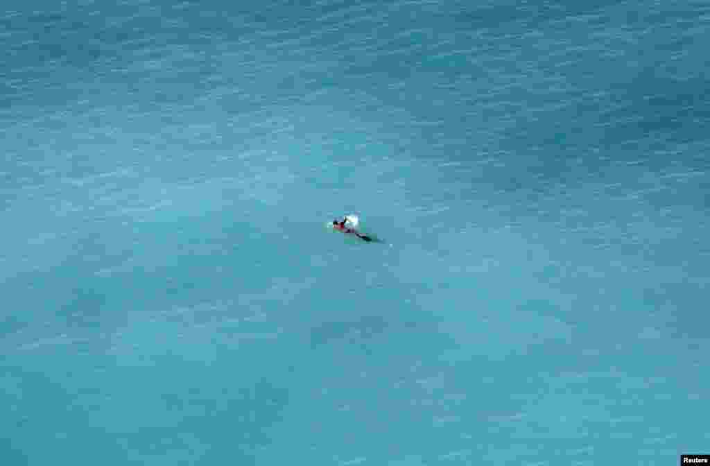 A man swims in the Mediterranean Sea during a warm and sunny winter day in Nice, France.