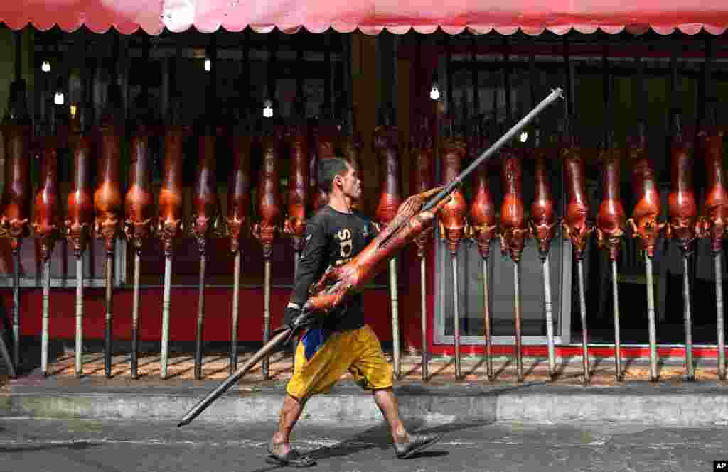 A worker carries a roasted pig to be served during Christmas eve dinner outside a store in Quezon city, Philippines, Dec. 24, 2013.