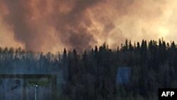 Smoke rises from a heavily wooded area in Fort McMurray, Alberta, May 3, 2016. Most residents were ordered to leave town after a wildfire swept through the oil sands region of Alberta. (Credit: Alberta Agriculture and Forestry Department)