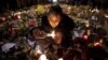 یک دختر جوان برای قربانیان حملات بروکسل شمع روشن می کند. 