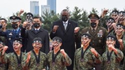 US Secretary of Defense Lloyd Austin, center, and South Korea's Defense Minister Suh Wook, center left, pose with members of South Korea's 2nd Army command during a taekwondo display at a ceremony at the great parade ground in the Ministry of National Def