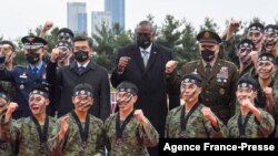 US Secretary of Defense Lloyd Austin, center, and South Korea's Defense Minister Suh Wook, center left, pose with members of South Korea's 2nd Army command during a taekwondo display at a ceremony at the great parade ground in the Ministry of National Def