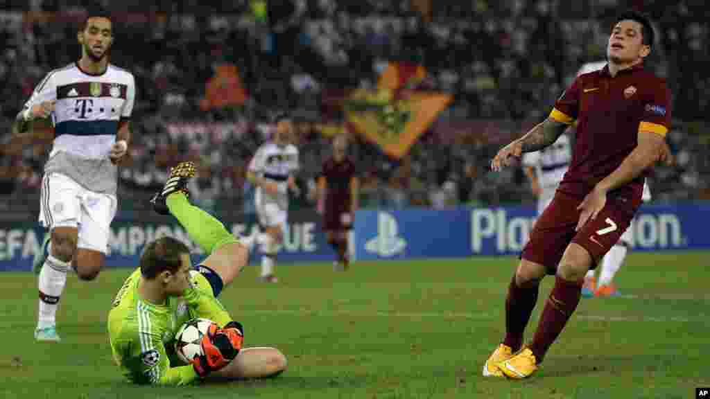 Le gardien de but du Bayern Manuel Neuer, à gauche, sauve la balle passé&nbsp; par Juan Manuel Arevalos Iturbe pendant le match de football du Groupe E de la Ligue des Champions&nbsp;entre Roma et le Bayern Munich au stade olympique, à Rome, le mardi 21 octobre, 2014.