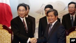 Menlu Jepang Fumio Kishida, kiri, berjabat tangan dengan Menteri Perencanaan dan Investasi Vietnam Bui Quang Vinh.