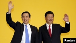 FILE - Chinese President Xi Jinping and Taiwan's then-president Ma Ying-jeou, left, wave to the media during a summit in Singapore, Nov. 7, 2015. 