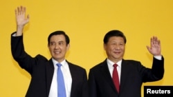 Chinese President Xi Jinping and Taiwan's President Ma Ying-jeou, left, wave to the media during a summit in Singapore, Nov. 7, 2015.