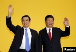 FILE - Chinese President Xi Jinping and Taiwan's President Ma Ying-jeou, left, wave to the media during a summit in Singapore, Nov. 7, 2015.