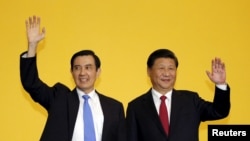 Chinese President Xi Jinping and Taiwan's President Ma Ying-jeou, left, wave to the media during a summit in Singapore, Nov. 7, 2015. 