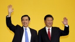FILE- Taiwan's President Ma Ying-jeou and Chinese President Xi Jinping right, wave to the media during a summit in Singapore, Nov. 7, 2015. 