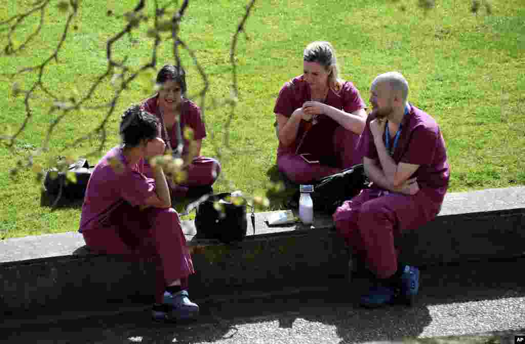 چند تن از کارکنان بیمارستان سنت توماس که بوریس جانسون نخست وزیر بریتانیا به دلیل ابتلا به کووید۱۹ در آن بستری است، برای استراحت در خارج از بیمارستان نشسته&zwnj;اند.