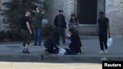 Прохожие помогают пострадавшему от удара минигрузовика человеку. Торонто, Канада. 23 апреля 2018 г.