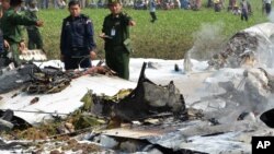 Des militaires inspectent l'épave d'un avion militaire du Myanmar qui est écrasé dans une zone proche de l'aéroport de Naypyitaw, le Myanmar, le mercredi 10 février 2016. (AP Photo / Aung Oo Brillance)