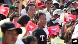 Participants holding national and military flags attend a ceremony supporting the country's military and civil servants, Oct. 29, 2017, in Yangon, Myanmar.