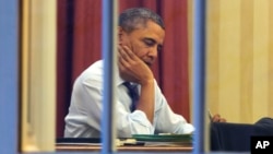 President Barack Obama works at his desk in the Oval Office of the White House in Washington, Jan. 27, 2014, ahead of Tuesday night's State of the Union speech.