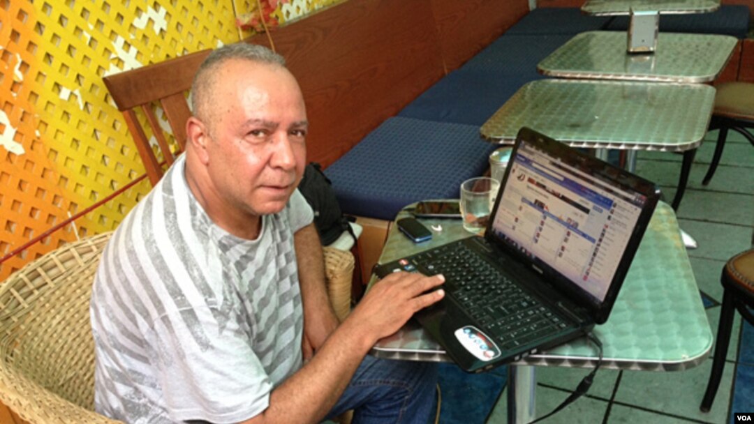 Mohamed Suleyman in New York City monitors a live social media newsfeed from his native Cairo. (VOA Photo A. Phillips)