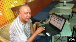 Mohamed Suleyman in New York City monitors a live social media newsfeed from his native Cairo. (VOA Photo A. Phillips)
