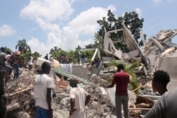 Warge berusaha mencari korban selamat di antara reruntuhan bangunan Hotel Manguier di Les Cayes, Haiti.