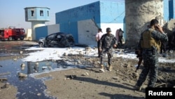 Iraqi security forces are seen at the site of a suicide bombing at a police checkpoint near Tikrit, Nov. 13, 2013.