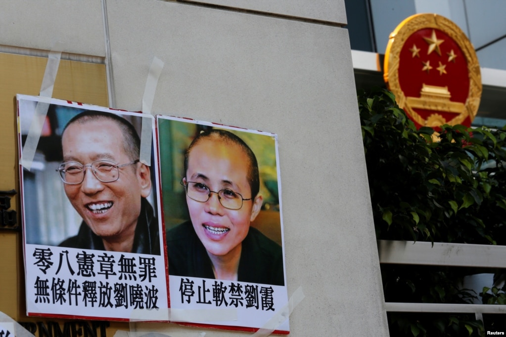 2017年6月27日,一些人在香港中联办外面示威,举着刘晓波夫妇的照片。