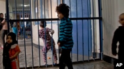 FILE - Children walking through the prison in Badam Bagh, Afghanistan's central women's prison, in Kabul.