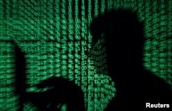 A man holds a laptop computer as code is projected on him in this illustration made on May 13, 2017. Capitalizing on spying tools believed to have been developed by the U.S. National Security Agency, hackers staged a cyberassault with a self-spreading malware that has infected tens of thousands of computers in dozens of countries.