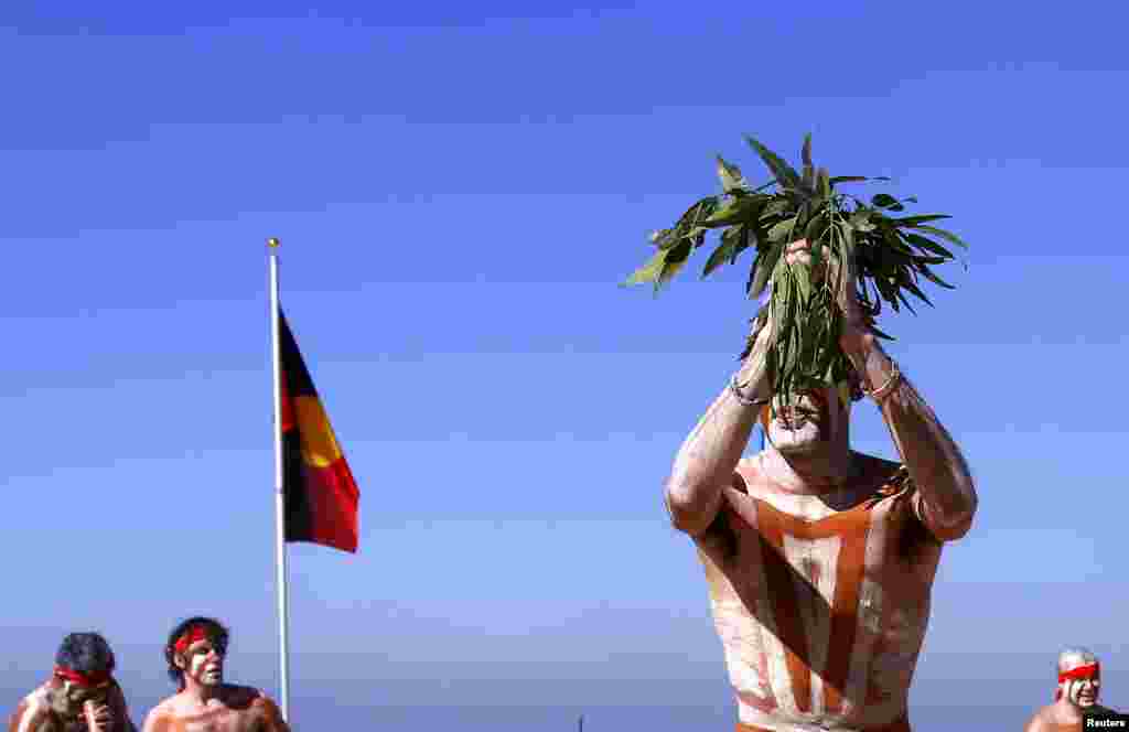 Traditonally dressed Australian Aboriginal performers hold gum-tree leaves as they dance on Sydney&#39;s Coogee Beach as they participate in a &#39;Corroboree&#39; showcasing traditional dance during an event to mark National Reconciliation Week.