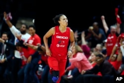 FILE - In this Oct. 10, 2019, file photo, Washington Mystics guard Kristi Toliver celebrates after her 3-point basket during the first half of Game 5 of basketball's WNBA Finals against the Connecticut Sun in Washington. Toliver is also an assistant coach