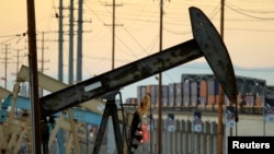 FILE - Oil rig pumpjacks, also known as thirsty birds, extract crude from the Wilmington Field oil deposits area where Tidelands Oil Production Company, owned by Occidental Petroleum Corporation, operates near Long Beach, California, July 30, 2013. 